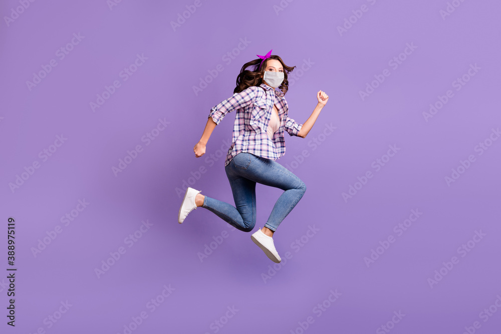 Profile photo of charming woman wear flu mask vintage checkered shirt jeans jump high isolated violet color background