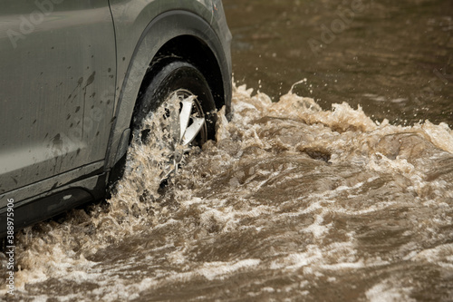 Фотография Suv car moving in high-water puddle (selective focus)