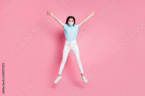 Full size photo of girl jump raise hands star wear blue fabric mask isolated over pink color background