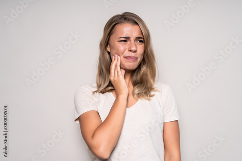 Portrait of young woman with toothache isolated on white background