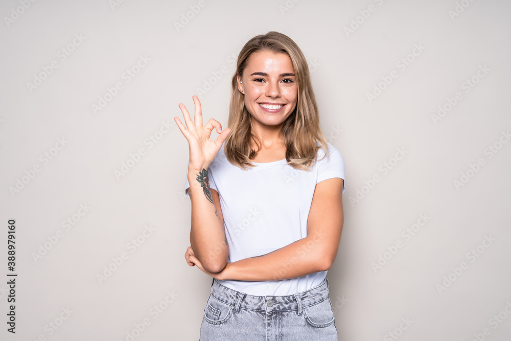 Happy smiling beautiful young woman showing okay gesture isolated over white background Happy smiling beautiful young woman showing okay gesture isolated over white background