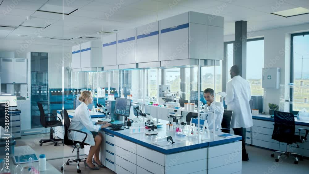 Bright High-Tech Medical Science Laboratory with Diverse Team of Professional Research Scientists Working with Microscopes, Computers. Developing Drugs, Vaccines, Medicine with Modern Equipment Bright High-Tech Medical Science Laboratory with Diverse Team of Professional Research Scientists Working with Microscopes, Computers. Developing Drugs, Vaccines, Medicine with Modern Equipment