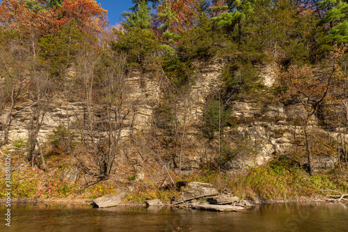 Root River In Autumn - A scenic river next to a cliff.