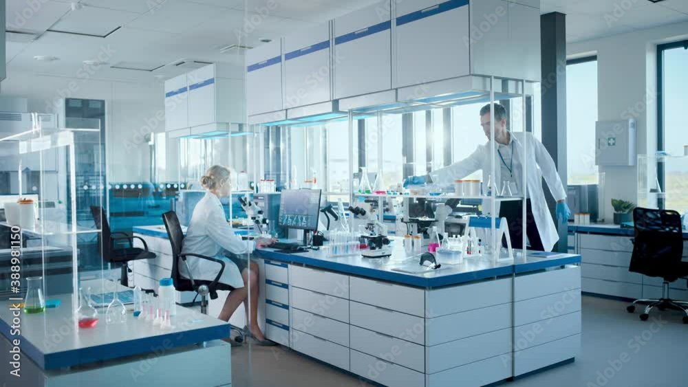 Medical Science Laboratory with Diverse Team of Professional Scientists Developing Drugs, Female Biochemist Working on Computer Display Showing Gene Editing Interface. High-Tech Equipment. Static Shot Medical Science Laboratory with Diverse Team of Professional Scientists Developing Drugs, Female Biochemist Working on Computer Display Showing Gene Editing Interface. High-Tech Equipment. Static Shot