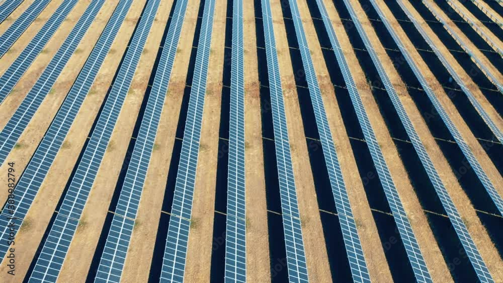 Flying over solar panel array. Renewable, eco-friendly energy concept.