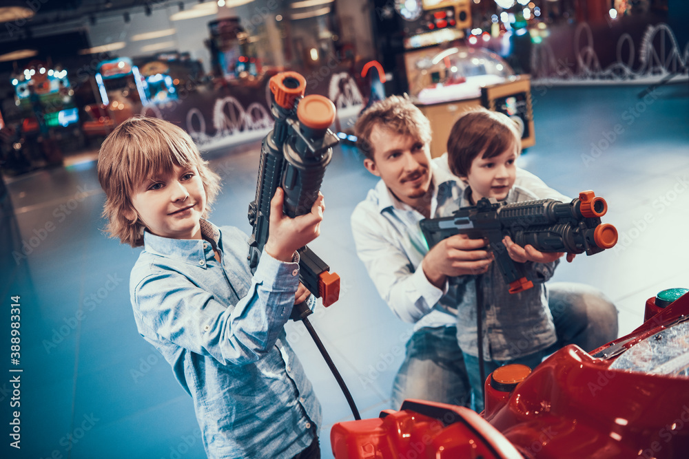 Dad teaches his sons to play shooting games. Dad teaches his sons to play shooting games.