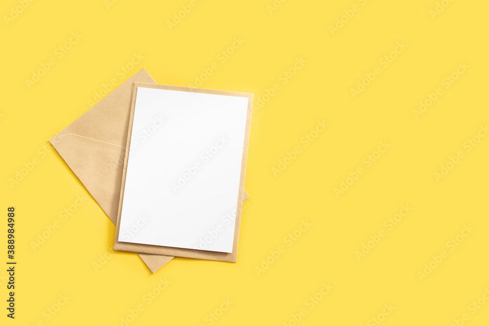 Kraft envelope and blank letter mockup on yellow background. Template with place for text on postcard. Envelope email concept. Kraft envelope and blank letter mockup on yellow background. Template with place for text on postcard. Envelope email concept.
