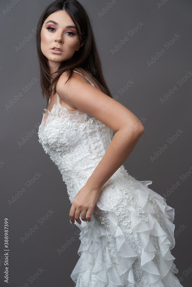 Beautiful bride in wedding dress posing on grey background Beautiful bride in wedding dress posing on grey background