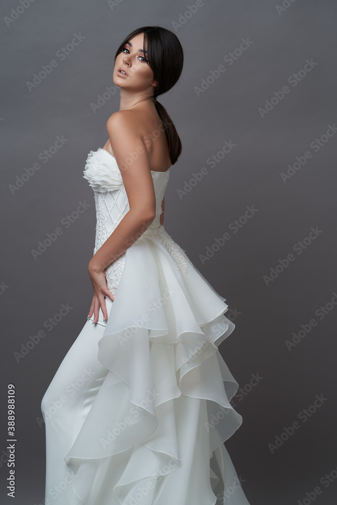 Beautiful bride in wedding dress posing on grey background Beautiful bride in wedding dress posing on grey background