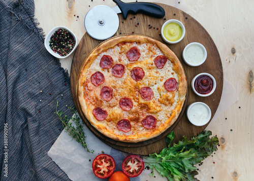 Tasty italian pizza made from an authentic recipe. Mozzarella topping mealted on top. Sauce aside. Professional product photography. photo