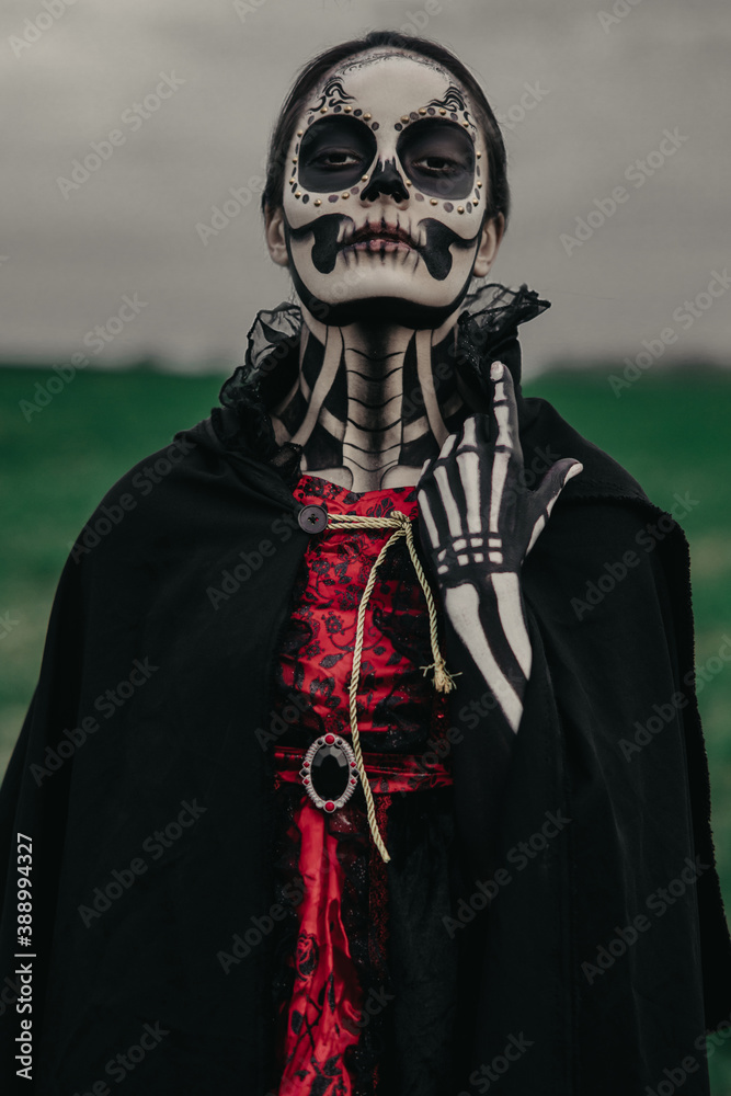 Portrait of woman in Halloween costume of death with painted skeleton and sugar skull makeup. Portrait of woman in Halloween costume of death with painted skeleton and sugar skull makeup.