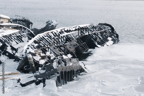 sunken old ships near the shore in the cemetery under the snow in winter