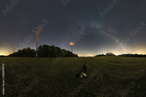 Summer relaxation, lying in the grass under the night sky and the Milky Way