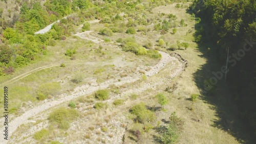 Aerial shot of a forest, road and dried up river
