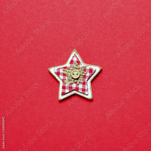 Wooden Christmas star decoration on red background. New Year Christmas minimal greeting card background. Flat lay.