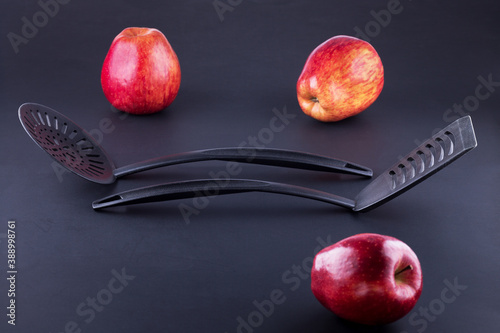Obraz na plátně black elegant kitchen utensils with beautiful red apples