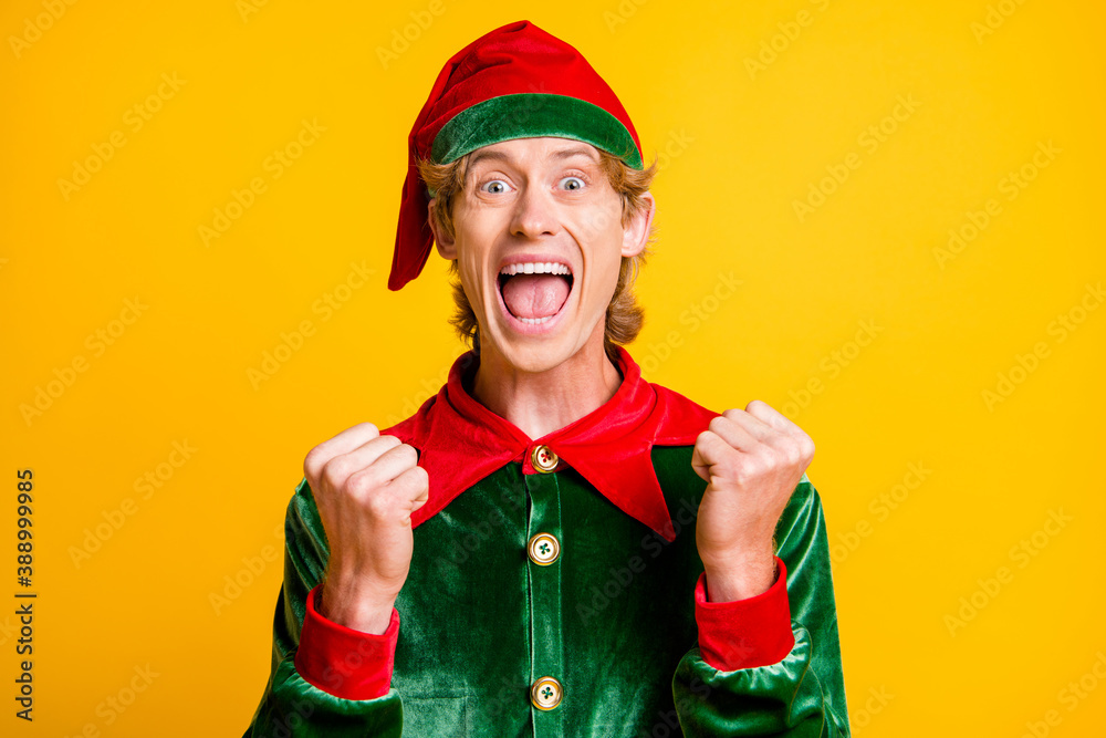 Photo of young mad guy raise fists open mouth wear elf velvet green costume headwear isolated yellow color background