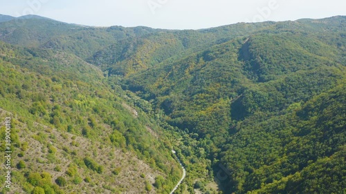 Aerial shot of a forest, road and dried up river
