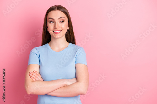Photo portrait of girl with folded arms looking at blank space isolated on pastel pink colored background