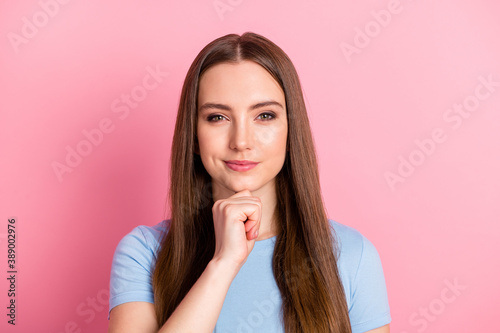 Photo portrait of woman touching face chin thinking isolated on pastel pink colored background