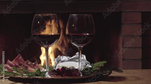 Two glasses of wine on fire background, dolly shot
