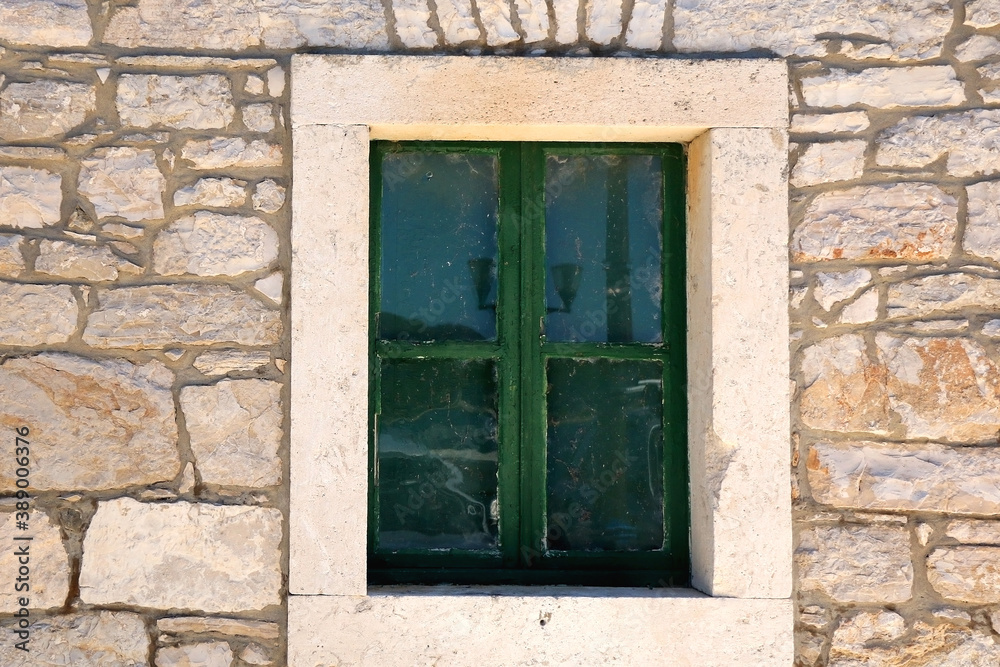 Traditional Mediterranean house with stone facade and wooden window.