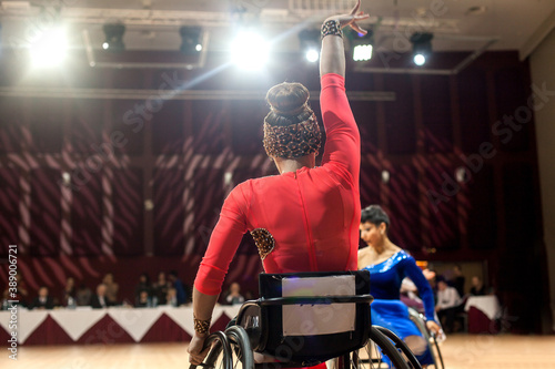 Competition of sports dances on wheelchairs. A woman with disabilities in fancy clothes dance in wheelchairs.