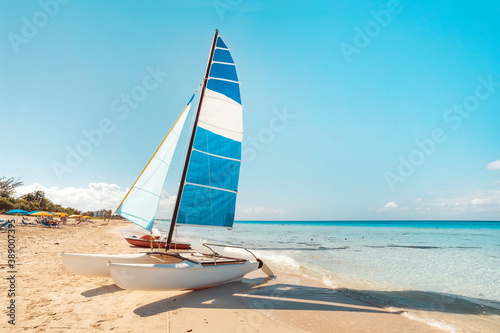 sailing catamaran is parked on the white sand on the seashore against the backdrop of beautiful tropical nature. tourist attractions in Cuba.