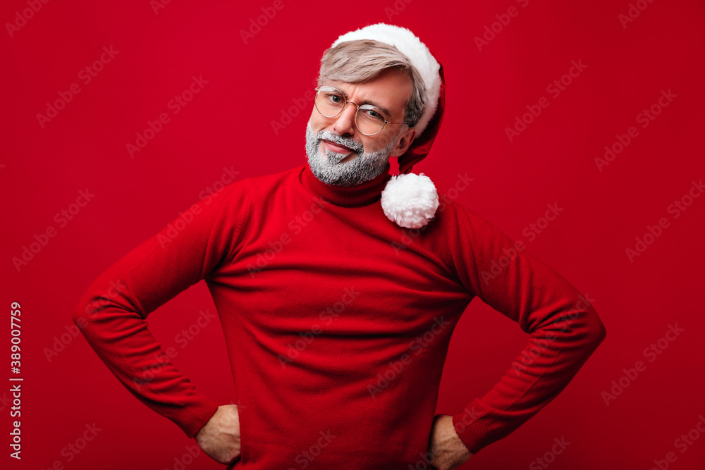 Pensive white-haired grandpa with beard looking to camera. Studio portrait of joyful santa claus wears glasses. Pensive white-haired grandpa with beard looking to camera. Studio portrait of joyful santa claus wears glasses.