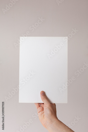 Hands hold a  sheet. Empty space for the label.