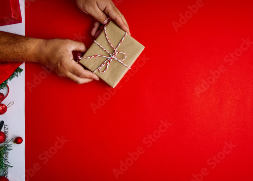 Male hands holding red gift on red background