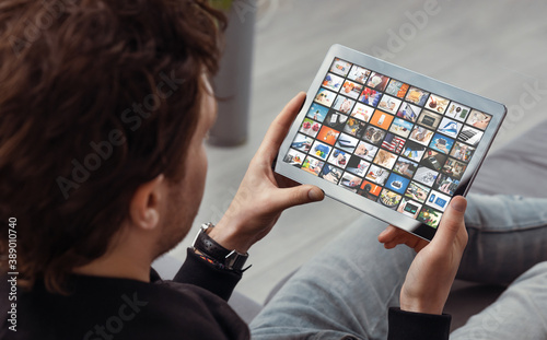 Man watching TV on tablet. Multimedia services