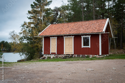 Red Swedish cottage on the shore of lake Vattern, autumn © Krisztian