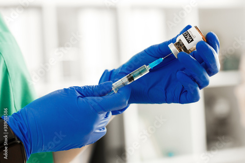 Doctor hands holding covid-19 vaccine preparing for vaccination of a patient