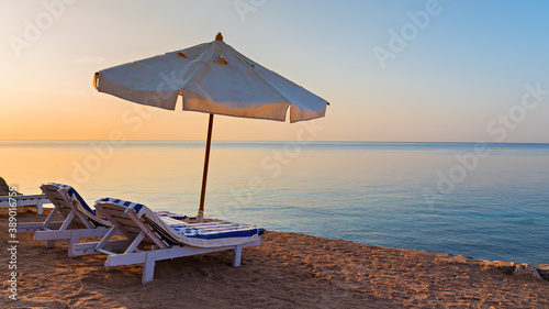 Beach area in luxury hotel with sun lounger and umbrella