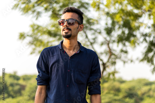 Portrait of young indian man, wearing blue shirt and denim jeans