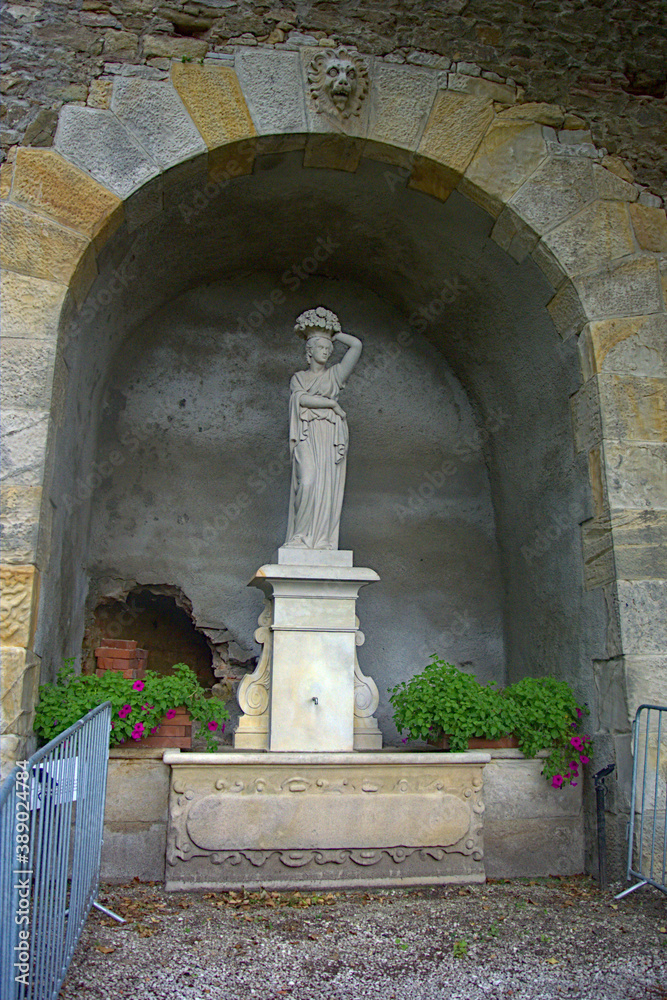 white marble statue under an archway