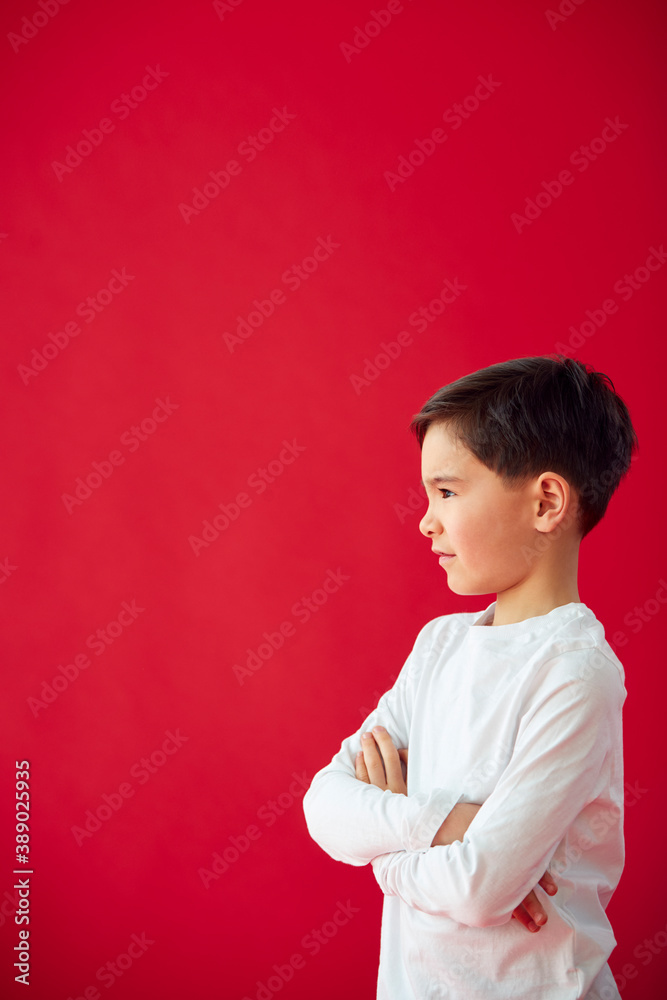 Portrait Of Young Boy With Folded Arms Against Red Studio Background Smiling At Camera Portrait Of Young Boy With Folded Arms Against Red Studio Background Smiling At Camera