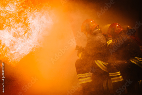 Firefighter training. fireman using water and extinguisher