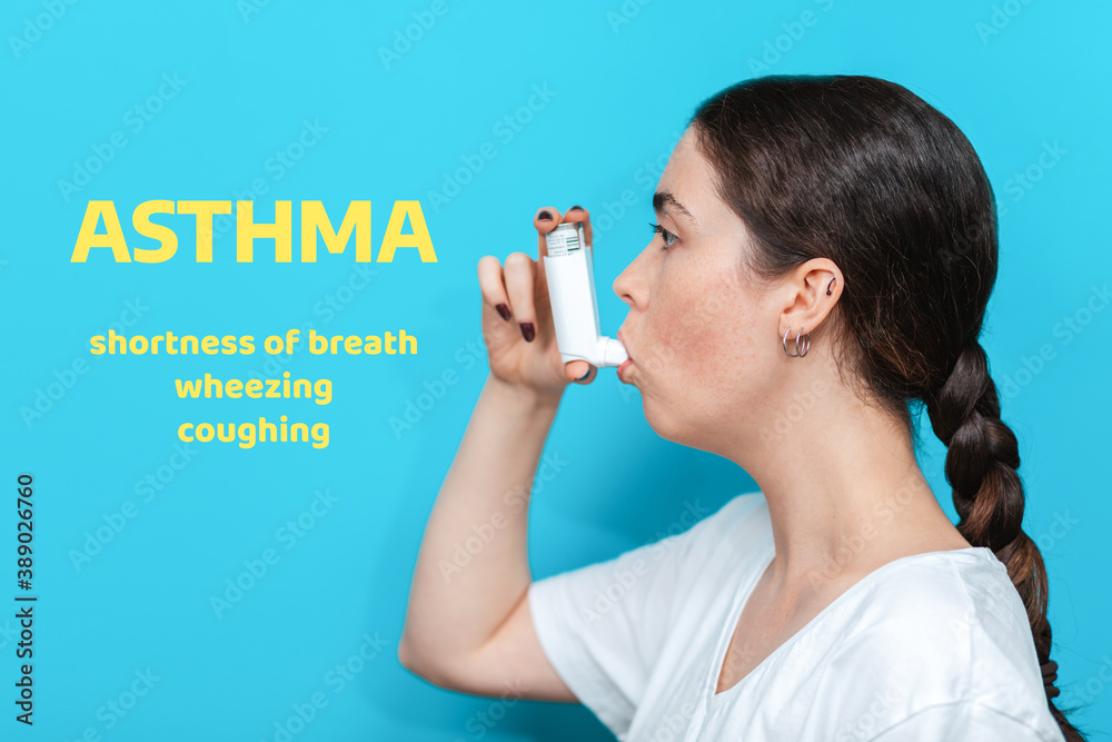 Symptoms of asthma. Portrait of a young woman using an inhaler. Blue background. Side view. Text Symptoms of asthma. Portrait of a young woman using an inhaler. Blue background. Side view. Text