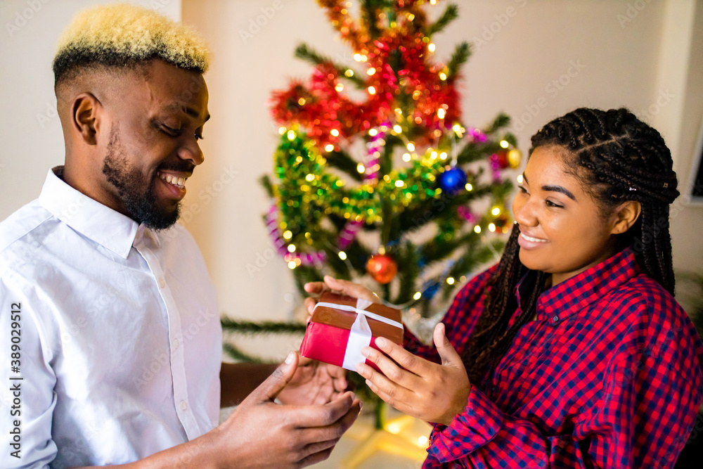 african american happy couple in love present a gift box in livingroom african american happy couple in love present a gift box in livingroom