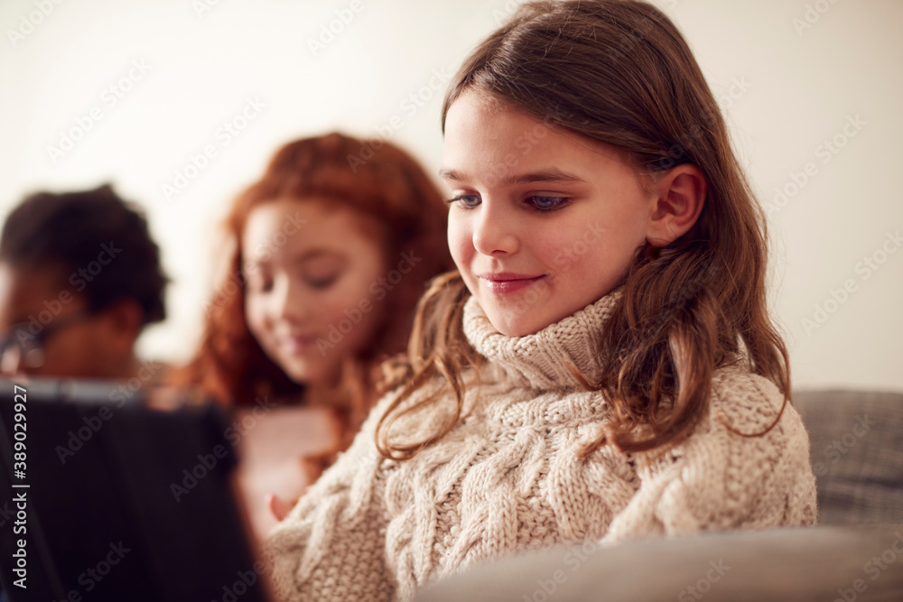 Group Of Children With Friends Sitting On Sofa At Home Playing Together On Digital Devices Group Of Children With Friends Sitting On Sofa At Home Playing Together On Digital Devices