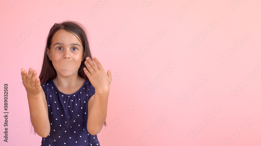 Portrait of an emotional 8-year-old girltaped her mouth. pink background Portrait of an emotional 8-year-old girltaped her mouth. pink background