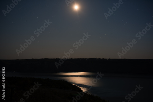 long exposure night photograph of the starry sky, moon and river © Andrii