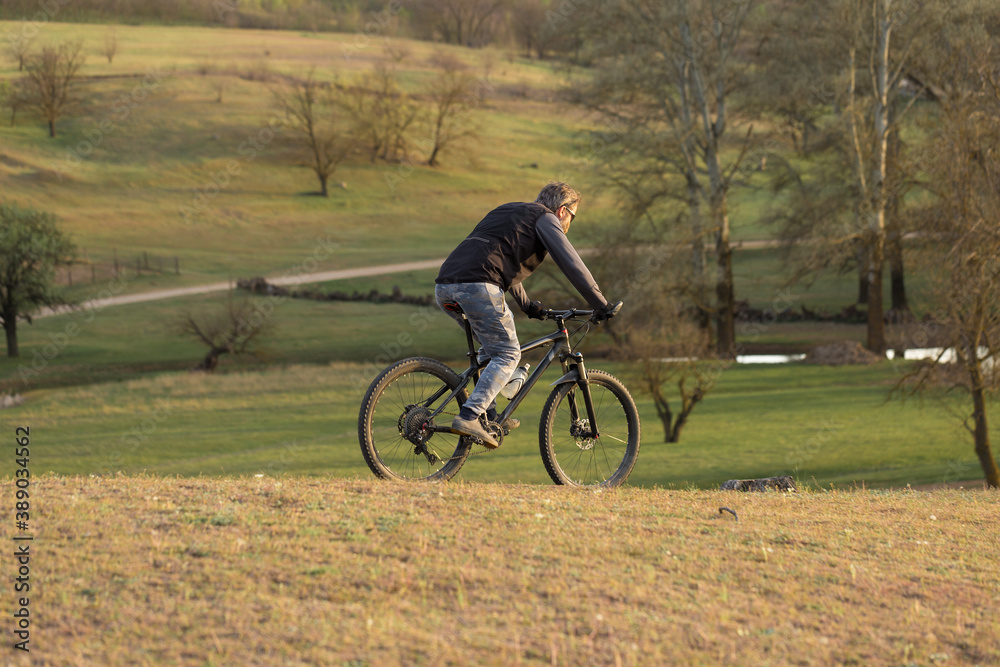Sports brutal bearded guy on a modern mountain bike. Cyclist on the green hills in the spring. Sports brutal bearded guy on a modern mountain bike. Cyclist on the green hills in the spring.