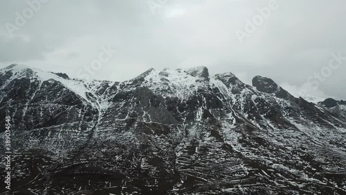 Aerial view of a high mountain landscape on a cloudy day with snow and lake 