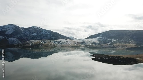 Aerial view of a high mountain landscape on a cloudy day with snow and lake 