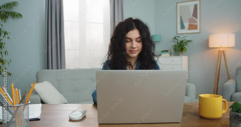 Charming Caucasian female sitting at table and chatting with friends on Internet indoors. Happy adult woman typing message, reading e-mails and smiling at home. Social media, technology concept. Charming Caucasian female sitting at table and chatting with friends on Internet indoors. Happy adult woman typing message, reading e-mails and smiling at home. Social media, technology concept.