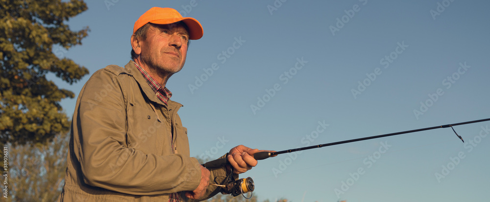 Fishing rod wheel closeup, man fishing with a beautiful sunset. Fishing rod wheel closeup, man fishing with a beautiful sunset.