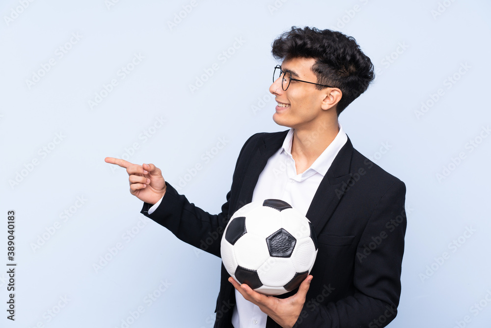 Argentinian Soccer coach over isolated blue background pointing to the side to present a product Argentinian Soccer coach over isolated blue background pointing to the side to present a product